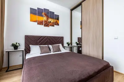 a bedroom with a bed and a painting of a giraffe at Lipovina Anres Apartment in Petrovac na Moru