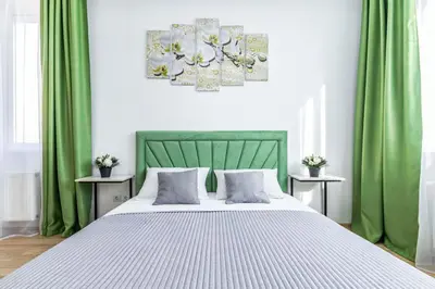 a bedroom with a large bed with green curtains at Lipovina Anres Apartment in Petrovac na Moru