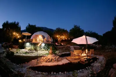 a garden with a tent and a table and umbrella at GO Glamping in Dobra Voda