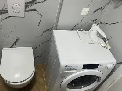 a washing machine with a phone on top of it in a bathroom at Alex apartment Bar in Bar