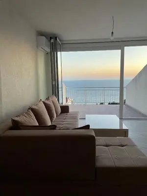 a living room with a couch and a view of the ocean at Sea House E&F in Ulcinj
