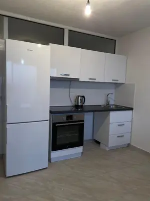 a kitchen with white cabinets and a white refrigerator at Sea House E&F in Ulcinj