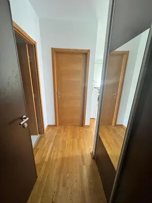 an empty hallway with a door and a wooden floor at Nema 2 in Kravlja
