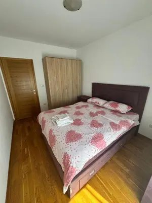 a bedroom with a bed with a red and white comforter at Nema 2 in Kravlja