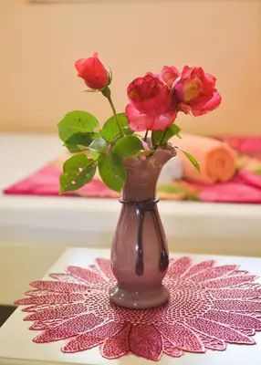 a vase with roses in it sitting on a table at M&D Apartments Jaz in Budva