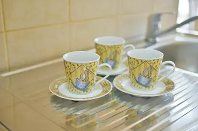 three cups and saucers sitting on a glass counter at M&D Apartments Jaz in Budva