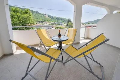 a patio with three chairs and a table on a balcony at M&D Apartments Jaz in Budva