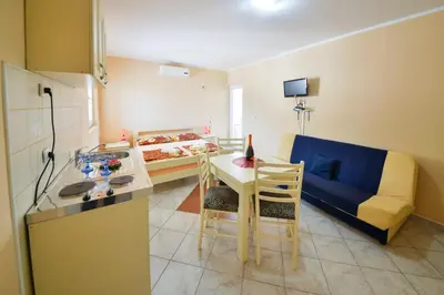 a kitchen and living room with a table and a couch at M&D Apartments Jaz in Budva