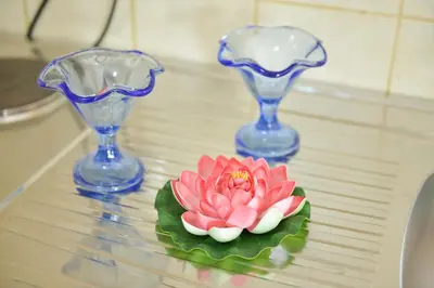 a pink flower on a table with two blue vases at M&D Apartments Jaz in Budva
