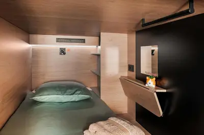a small bedroom with a bed and a mirror at U-NIGHT Hostel Budva in Budva