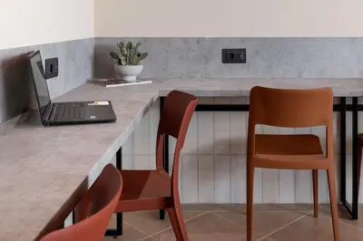 a kitchen with a laptop on a counter with two chairs at U-NIGHT Hostel Budva in Budva