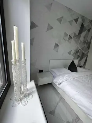 a bedroom with a bed and two candles on a table at Apartments Silversany in Budva