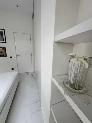 a white room with a white wall and a shelf at Apartments Silversany in Budva
