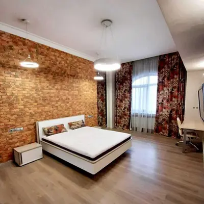 a bedroom with a bed and a brick wall at Apartments Jimasly in Budva
