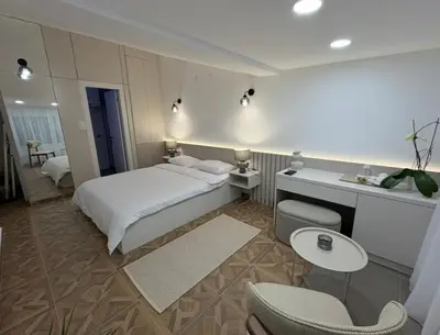 a bedroom with a bed and a table and chairs at Gymnasium Rooftop Suite in Podgorica