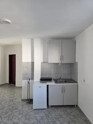 an empty kitchen with white cabinets and a sink at SHARRI Apartments in Ulcinj