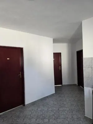 an empty room with two doors and a tile floor at SHARRI Apartments in Ulcinj