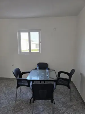 a table and chairs in a room with a window at SHARRI Apartments in Ulcinj