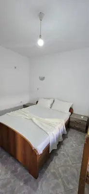 a bedroom with a large bed with white sheets at SHARRI Apartments in Ulcinj