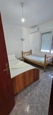 two beds in a room with a door open at SHARRI Apartments in Ulcinj