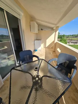 a glass table and two chairs on a balcony at SHARRI Apartments in Ulcinj