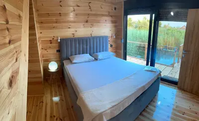a bedroom with a bed in a wooden wall at Era Cottage in Ulcinj