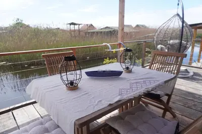 a table on a deck with two chairs and a sink at Era Cottage in Ulcinj