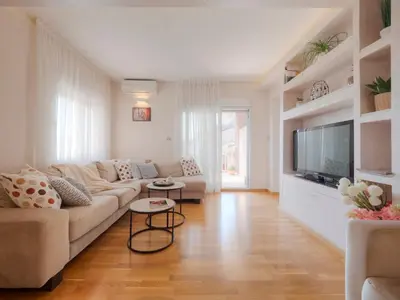 a living room with a couch and a flat screen tv at Tucked in 2br apt with terrace in Budva in Budva