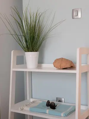 a white shelf with a potted plant on it at Tucked in 2br apt with terrace in Budva in Budva