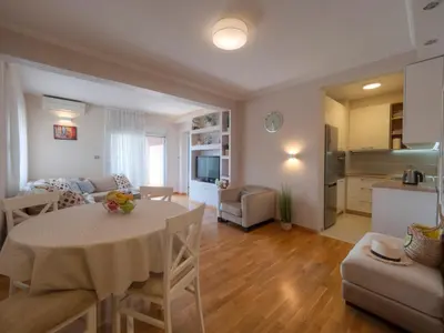a kitchen and a living room with a table in a room at Tucked in 2br apt with terrace in Budva in Budva