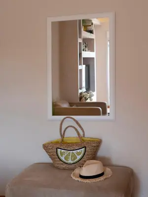 a mirror on a wall with a hat and a basket at Tucked in 2br apt with terrace in Budva in Budva