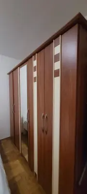 a row of wooden cupboards in a bedroom at Аппартаменты Магнолия in Petrovac na Moru