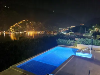 a swimming pool at night with a view at Studio apartment with heated pool in Kotor