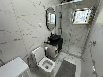 a bathroom with a toilet and a sink and a mirror at Studio apartment with heated pool in Kotor