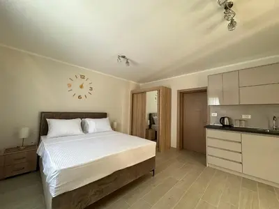 a bedroom with a bed and a clock on the wall at Studio apartment with heated pool in Kotor