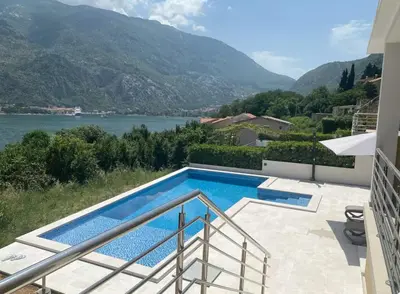a swimming pool with a view of a mountain at Studio apartment with heated pool in Kotor