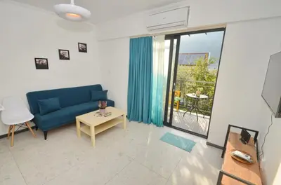 a living room with a blue couch and a table at Apartments Spasoje in Kotor