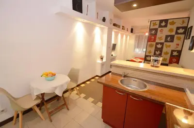 a kitchen with a sink and a table with a bowl of fruit at Apartments Spasoje in Kotor