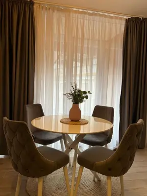 a table with chairs and a vase of flowers on it at Budva APT in Budva