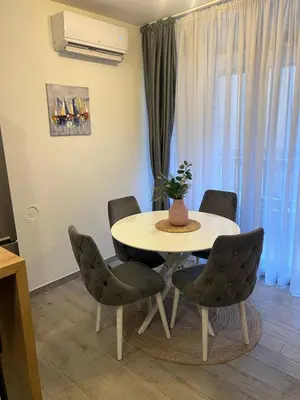 a table and chairs in a living room with a table at Budva APT in Budva