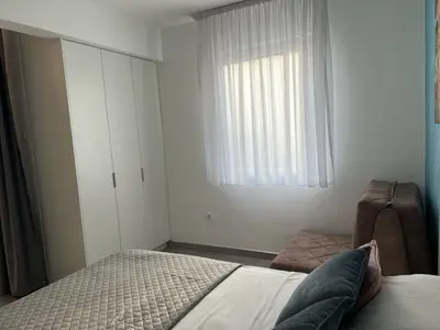a white bedroom with a bed and a window at Budva APT in Budva