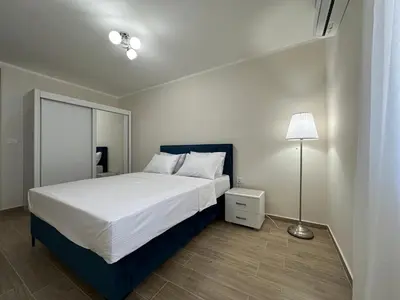 a bedroom with a white bed and a lamp at Sea view apartment with heated pool in Kotor