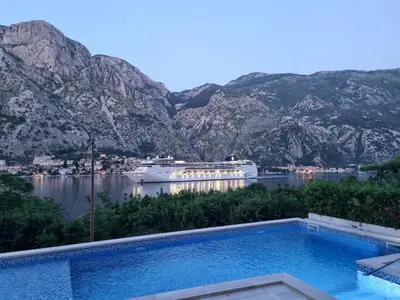 a swimming pool with a cruise ship in the water at Sea view apartment with heated pool in Kotor