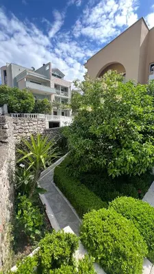 a garden with bushes and a building in the background at Golden Sun Apartment 2 in Ulcinj