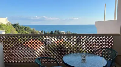 a table and chairs on a balcony with the ocean at Golden Sun Apartment 2 in Ulcinj