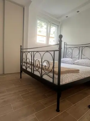 a black bed in a room with a window at Apartman Pablo in Kotor