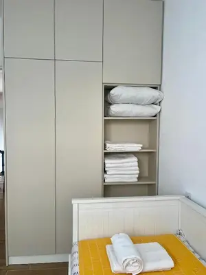 a closet with white cabinets and white towels at Apartman Pablo in Kotor