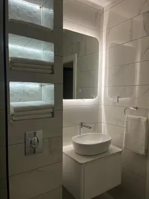 a white bathroom with a sink and a mirror at Apartman Pablo in Kotor