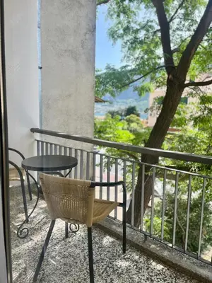 a chair and a table on a balcony with a tree at Apartman Pablo in Kotor