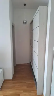 a bedroom with a dresser in a white room at Blue wave apartman in Becici